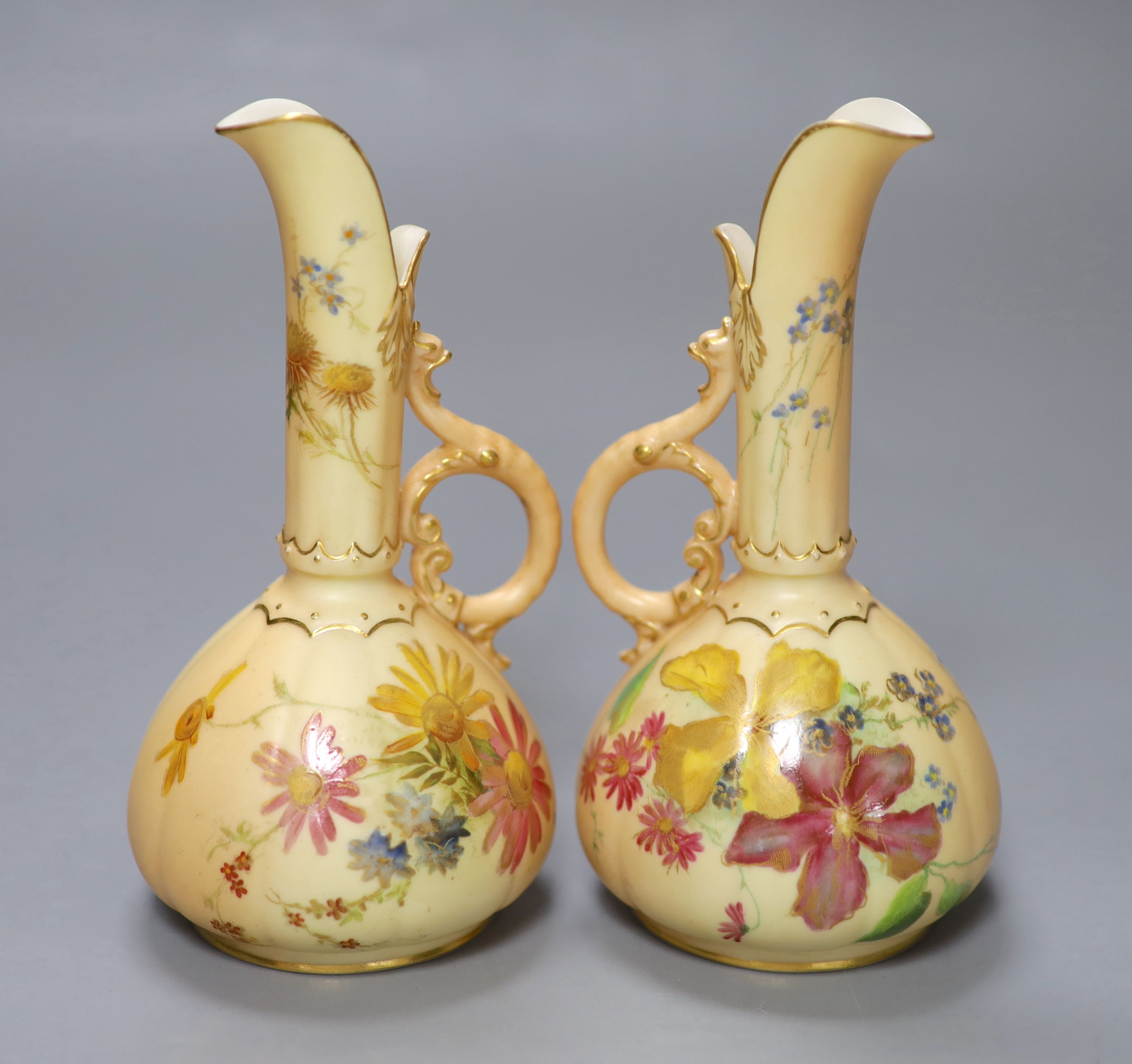 A pair of Royal Worcester blush ivory ewers painted and gilded with flowers, green mark, date code 1900, height 15cm